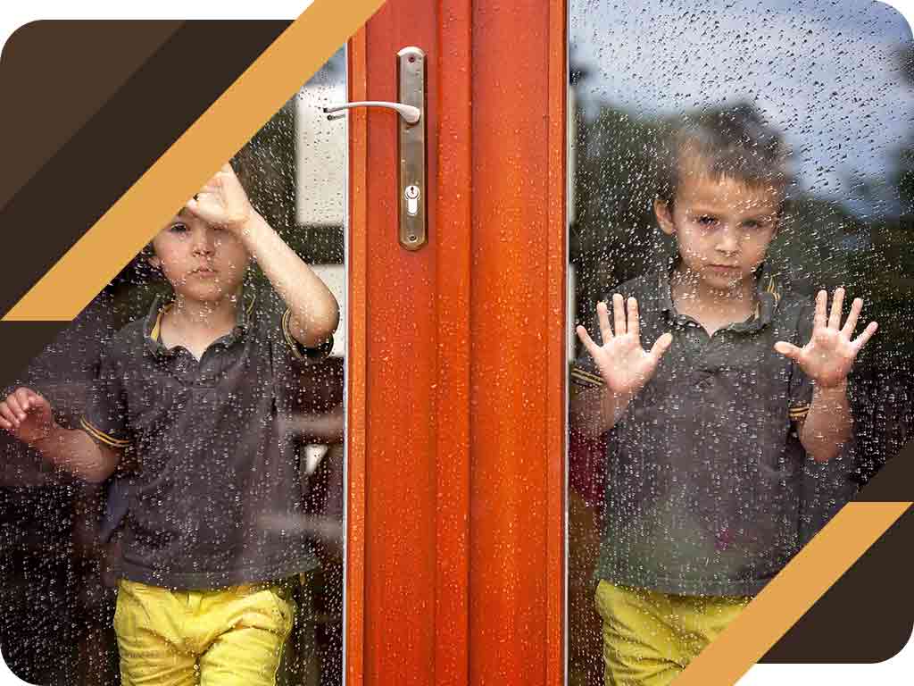 two boys against glass doors raining