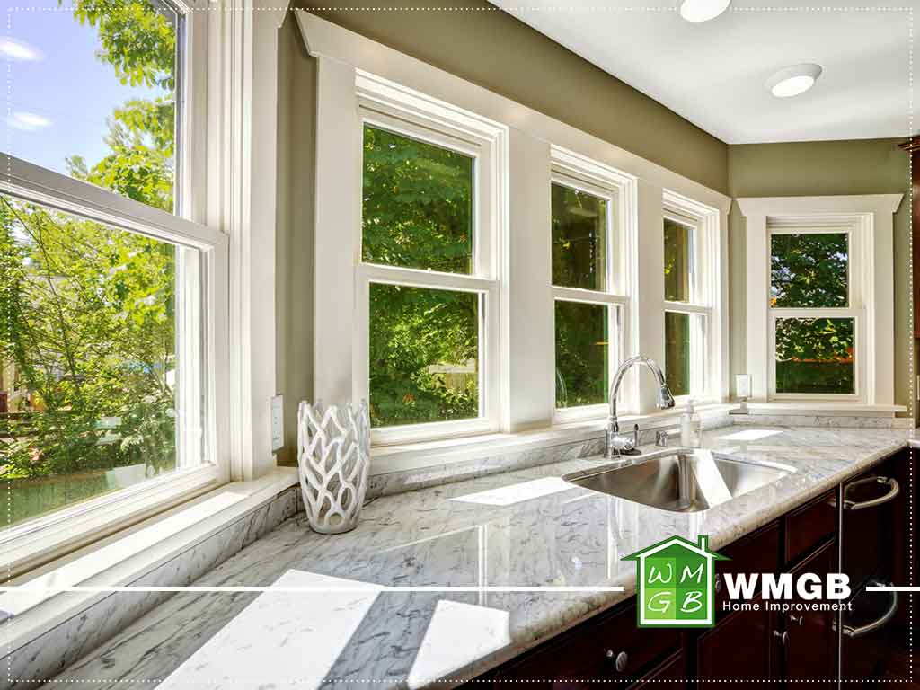 five windows in kitchen featuring sink and marble countertop
