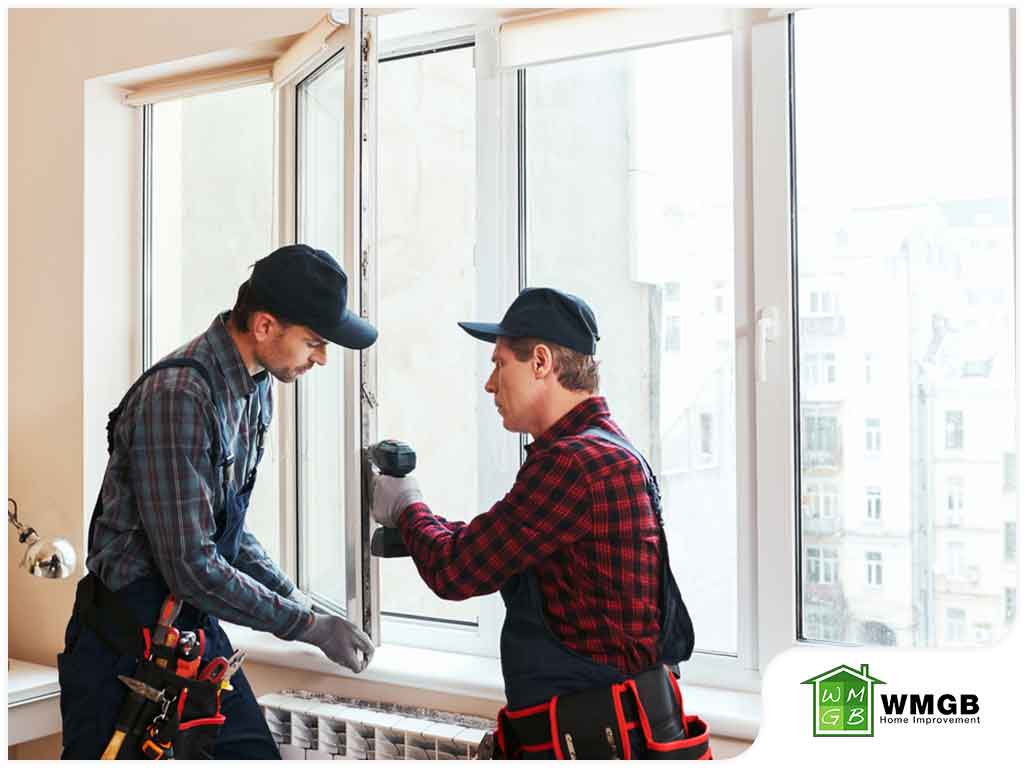 two technicians installing new windows in house