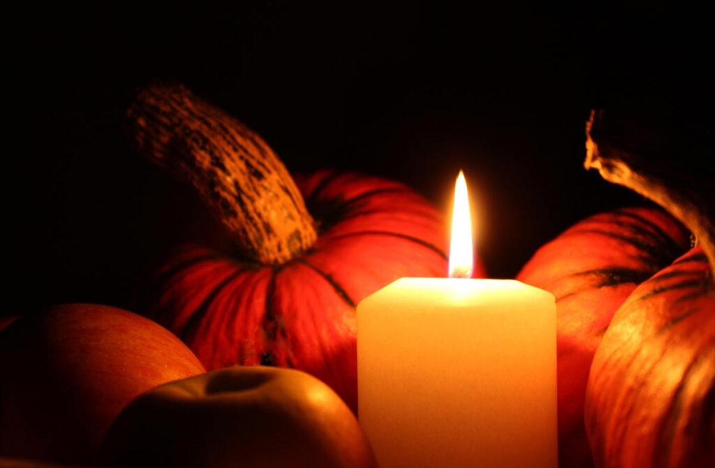 burning candle among pumpkins for october fire safety month