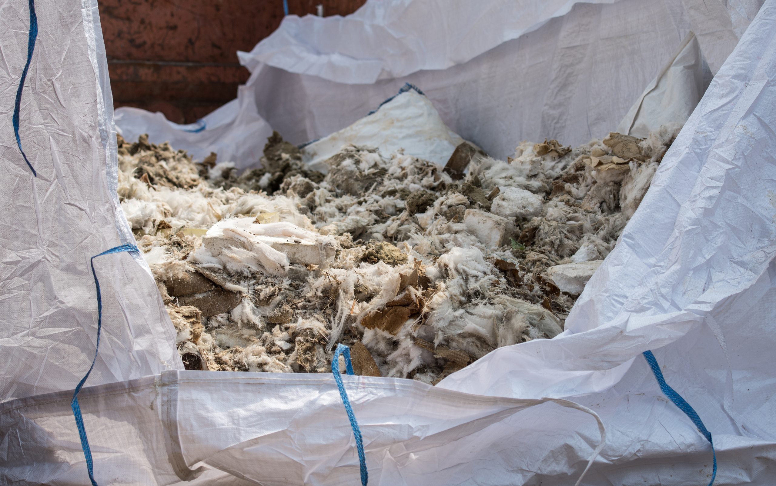 old insulation being removed into a bag