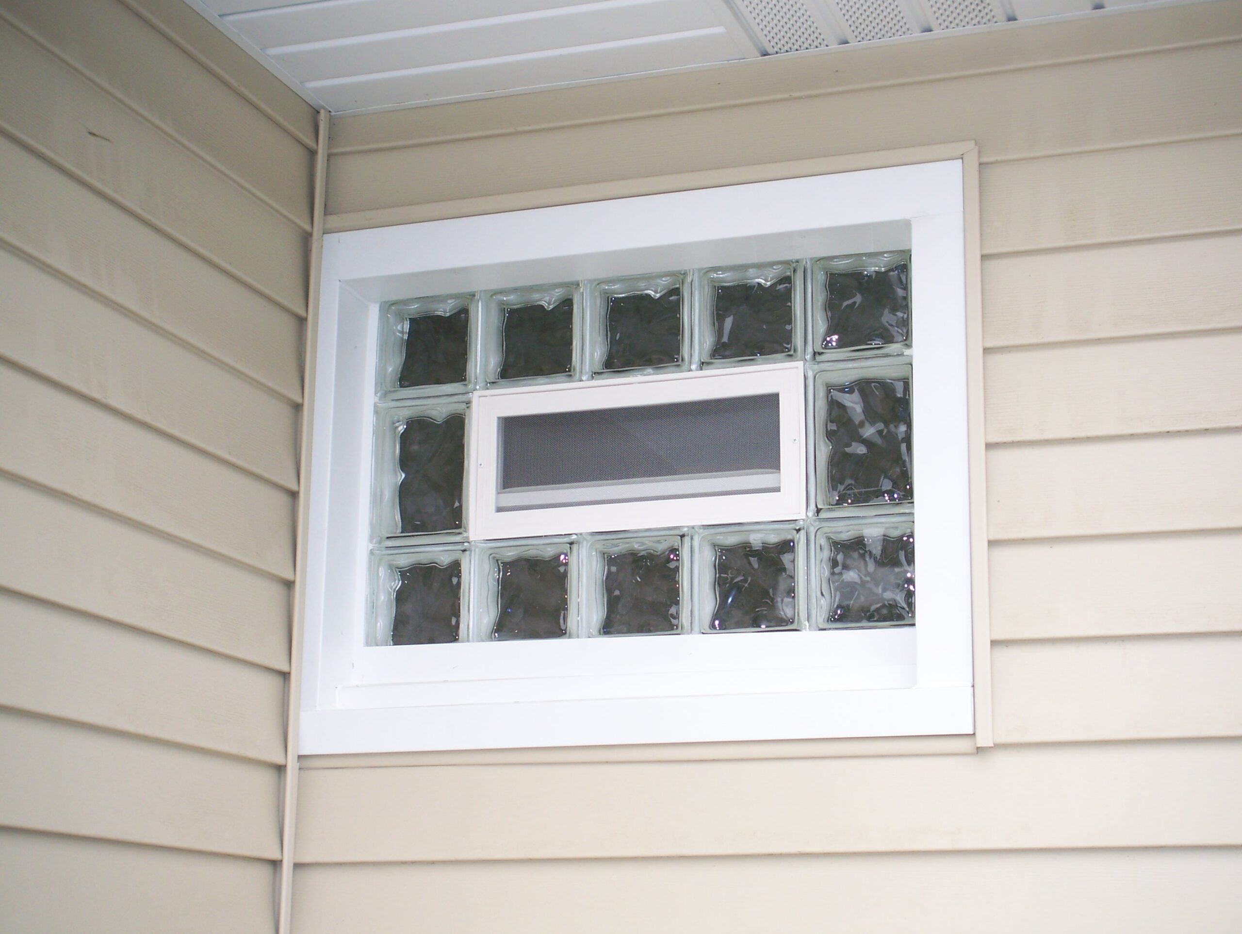 custom glass block window on the side of a house with vinyl siding